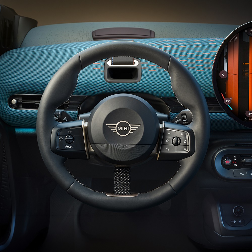 Interior de um MINI Aceman, com volante, painel digital e ecrã central circular visíveis